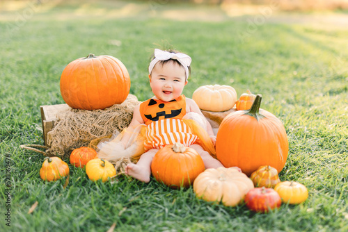 Slika na platnu Cute baby girl dressed in halloween  pumpkin costume