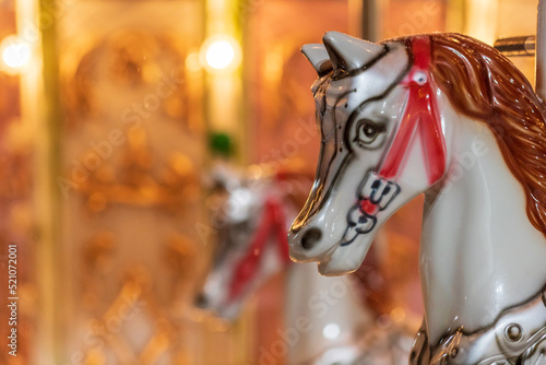 part of a horse mounted on a carousel, light bulbs on the carousel © metelevan