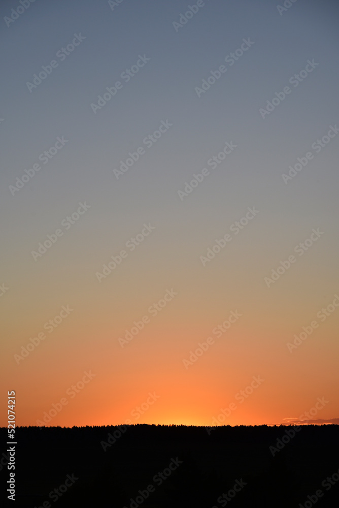 A clear evening sunset with blue and yellow reflections. Beautiful clear sunset.