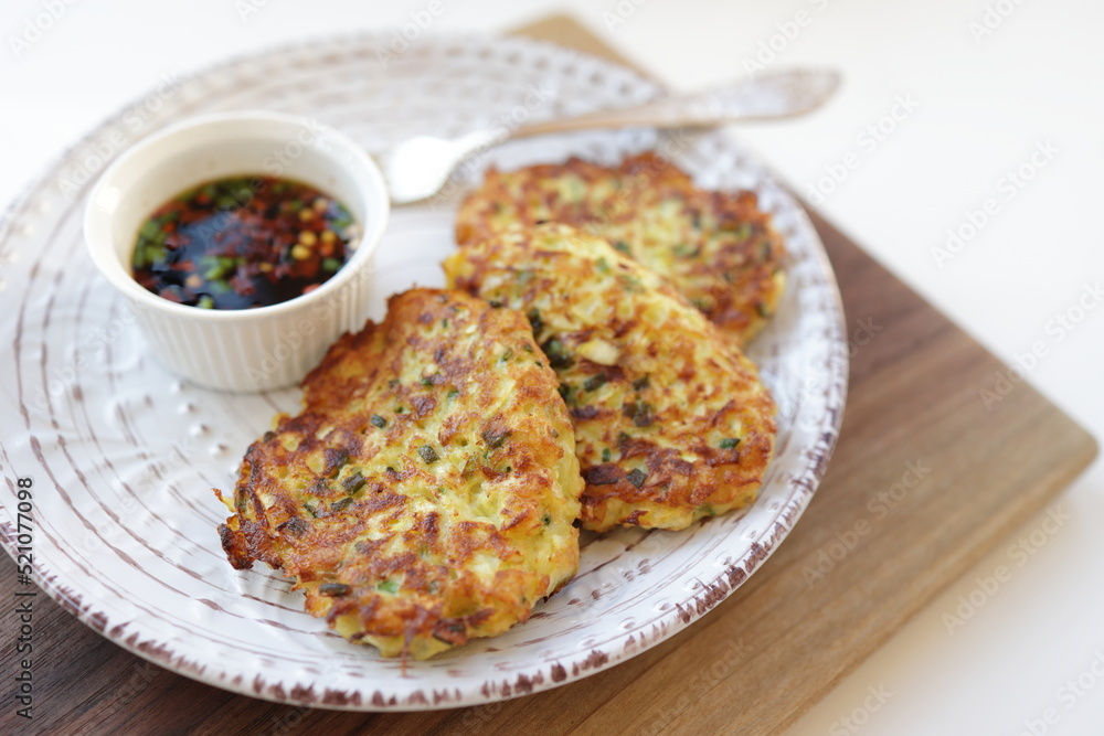 Zucchini fritters, vegetarian zucchini fritters, served with soy dipping sauce. Close-up