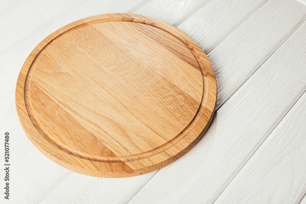Empty round kitchen board on white wooden background. Empty round kitchen board on white wooden background.