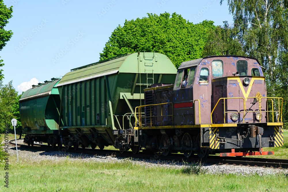 a small shunting diesel locomotive pulls two bulk wagons a small shunting diesel locomotive pulls two bulk wagons
