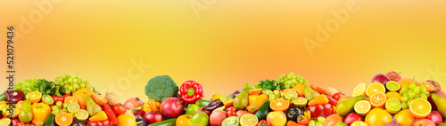 Large collection fruits, vegetables and berries on orange background.