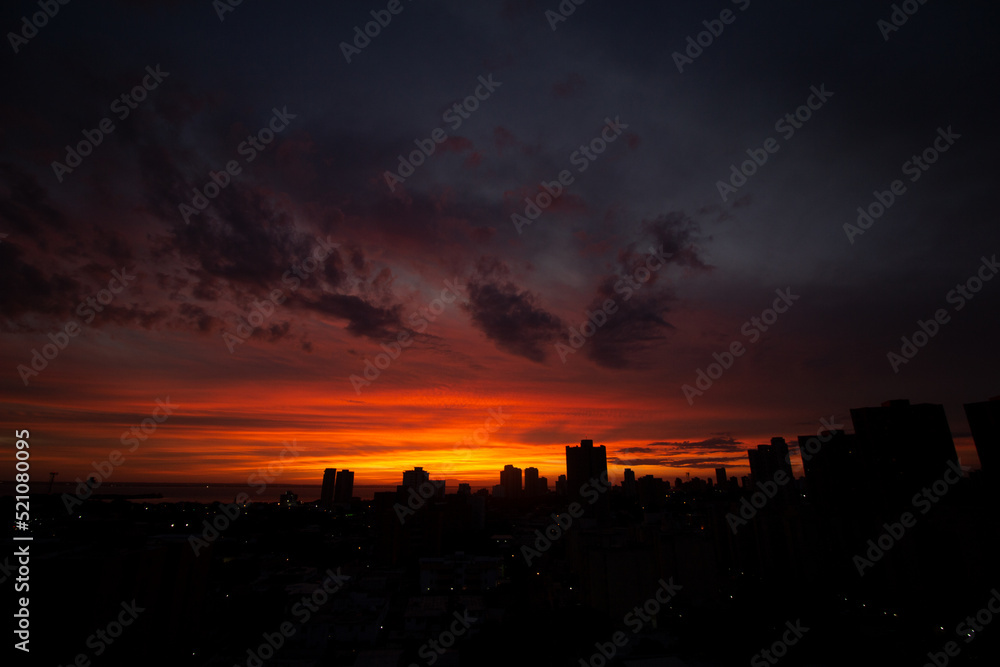 city skyline at sunset with spectacular orange pink and blue sky with clouds