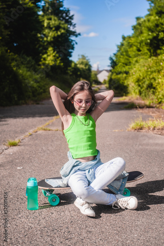 young girl with her skateboard on a sunny day in the park