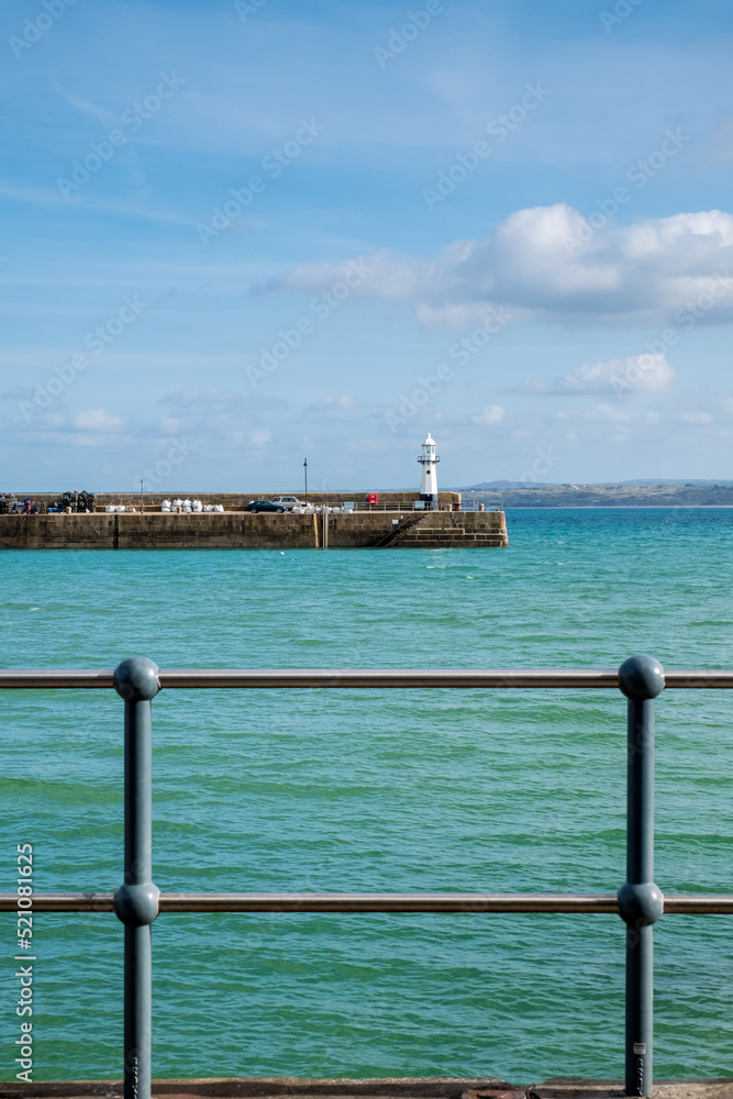 Metal railings protect pedestrians from falling into the sea at St Ives Harbour, St Ives, Cornall, UK