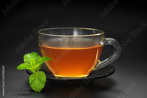 Cup of tea with mint on a black background close-up