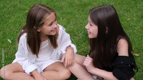 fraternal twins sisters. blonde and brunette teen girls in fashionable black and white clothes outdoors. sisterhood, siblings spending time together