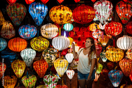 Mujer turista disfrutando de l  mparas coloridas del mercado nocturno de Hoi An  en Vietnam