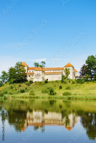 Svirzh Castle reflected in lake water. Lviv region, Ukraine