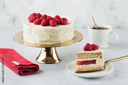 White cake with a wreath made of raspberries on the white background