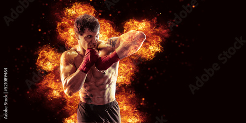 Fighter man punching in fire. MMA fighter © zamuruev
