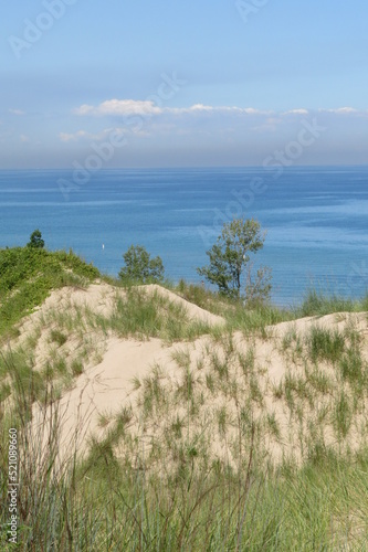 grassy sand dune overlooking great lake with sky and clouds