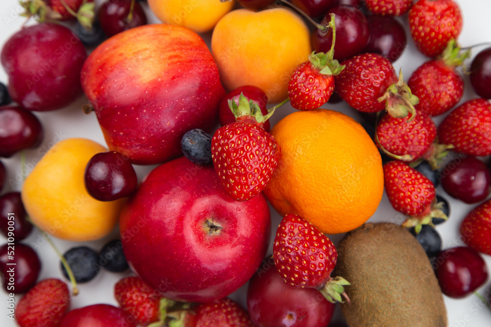 Different ripe fruits and berries lie in a solid layer on the white. High quality photo Different ripe fruits and berries lie in a solid layer on the white. High quality photo