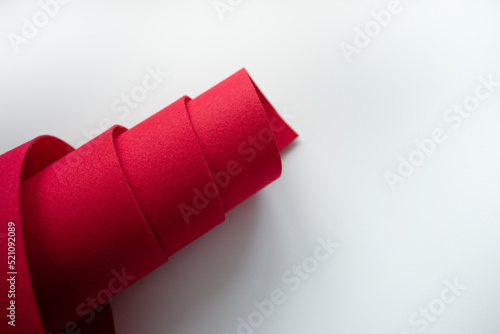 A roll of red felt fabric on a white background.Sale of fabric. Red material for sewing and crafts. photo