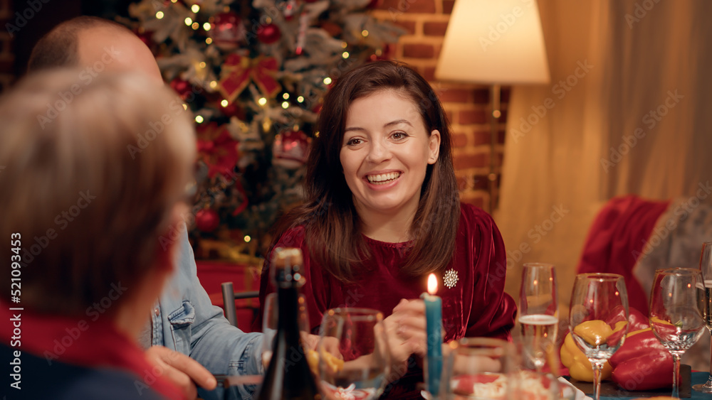 Beautiful wife chatting with senior woman while enjoying Christmas dinner at home. Festive family members eating traditional home cooked food while celebrating winter holiday. Tripod shot Beautiful wife chatting with senior woman while enjoying Christmas dinner at home. Festive family members eating traditional home cooked food while celebrating winter holiday. Tripod shot