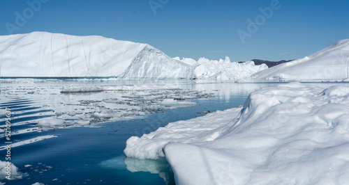 White and dazzling blue icebergs floating in the Ilulissat Icefjord in Greenland