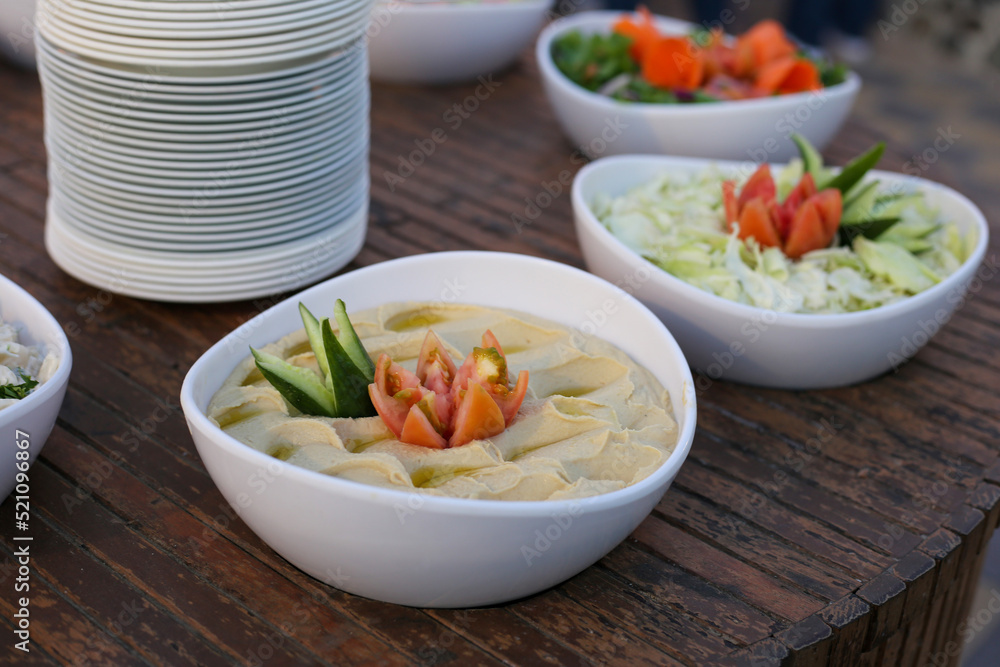 Hummus in white plate on wooden table. Arabic dish Hummus in white plate on wooden table. Arabic dish