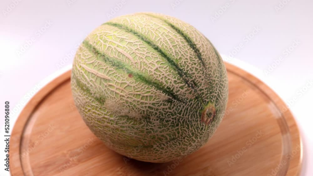 Close up view of Cantaloupe melon on wooden cutting board isolated Close up view of Cantaloupe melon on wooden cutting board isolated