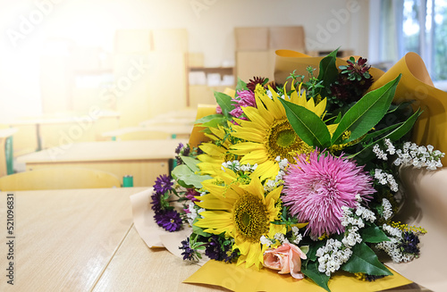 A bouquet of autumn flowers lies on a table in the classroom. Greeting card with the beginning of the school year at school. High quality photo photo