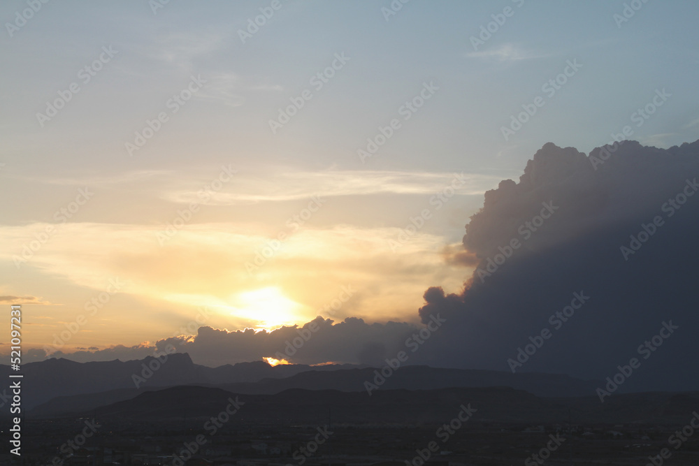 Wildfire smoke can be seen nearly blocking the desert sunset with mountains in the foreground