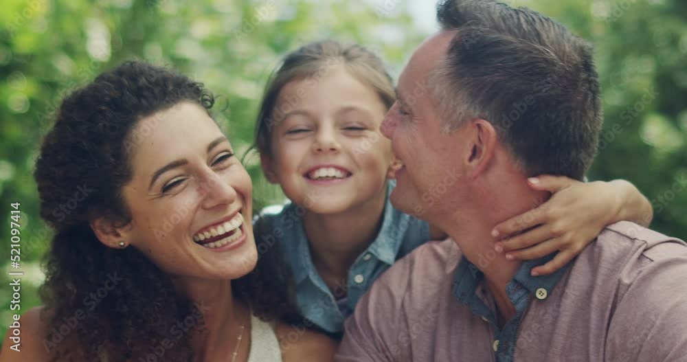 Cute adorable little girl embracing and hugging her mother and father outside. Smiling, happy and loving married couple bonding with their daughter. Husband and wife enjoying summer with their child Cute adorable little girl embracing and hugging her mother and father outside. Smiling, happy and loving married couple bonding with their daughter. Husband and wife enjoying summer with their child