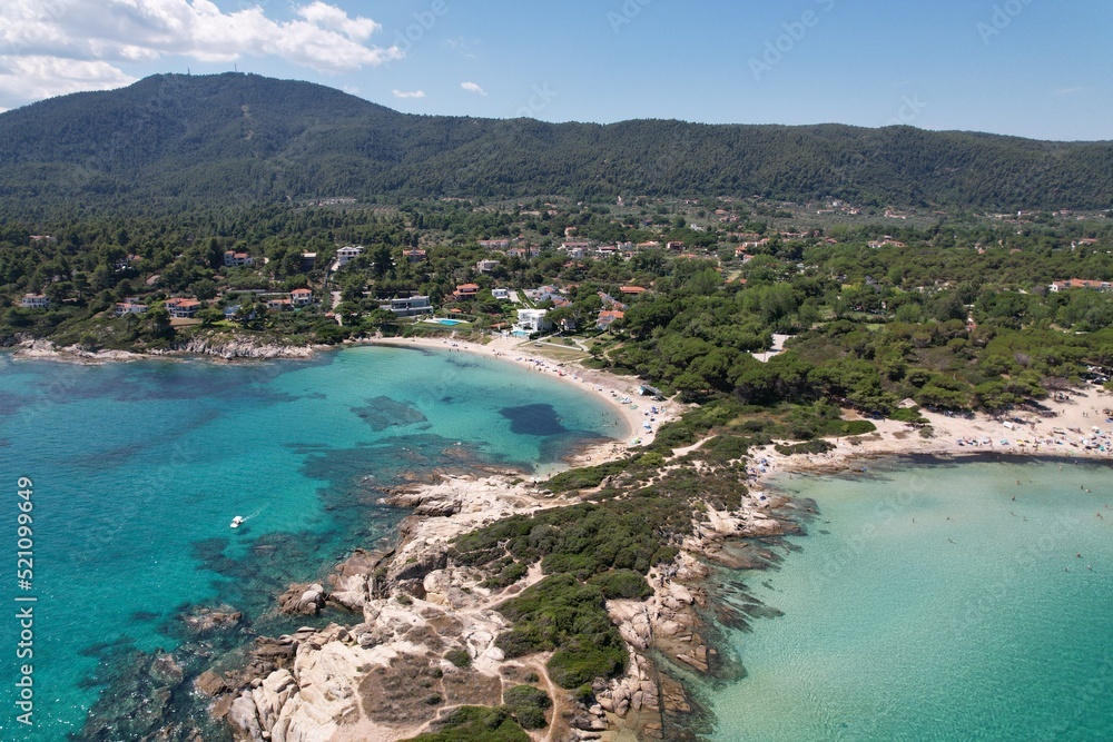 Calm Karydi beach near the village of Vourvourou in Greece. Aerial drive view of seashore and shallow see-through turquoise water. High quality photo