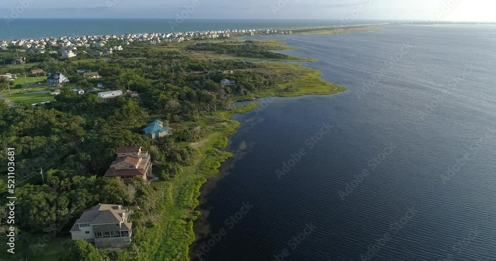 Drone shot of homes along the Pamlico Sound in the Outer banks near Frisco, NC with Hatteras in the background Drone shot of homes along the Pamlico Sound in the Outer banks near Frisco, NC with Hatteras in the background