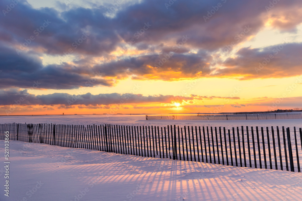 Shadows on a snow covered beach under golden sunset light. Jones Beach State Park - Wantagh New York