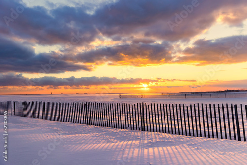 Shadows on a snow covered beach under golden sunset light. Jones Beach State Park - Wantagh New York