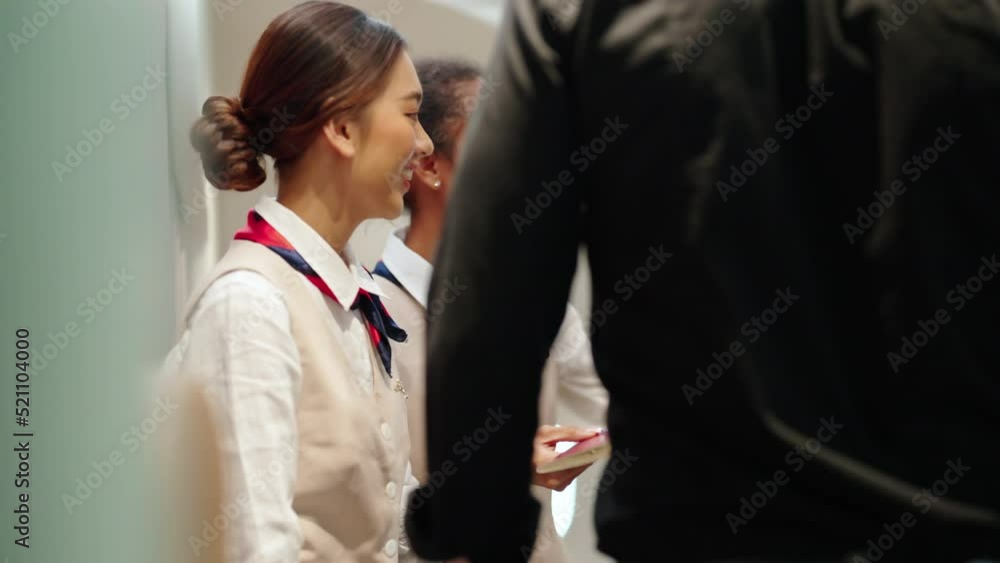 4K Woman flight attendant checking boarding pass and provide service to passenger in airplane. Passenger keep baggage in luggage compartment over the seat. Airline business and travel vacation concept 4K Woman flight attendant checking boarding pass and provide service to passenger in airplane. Passenger keep baggage in luggage compartment over the seat. Airline business and travel vacation concept