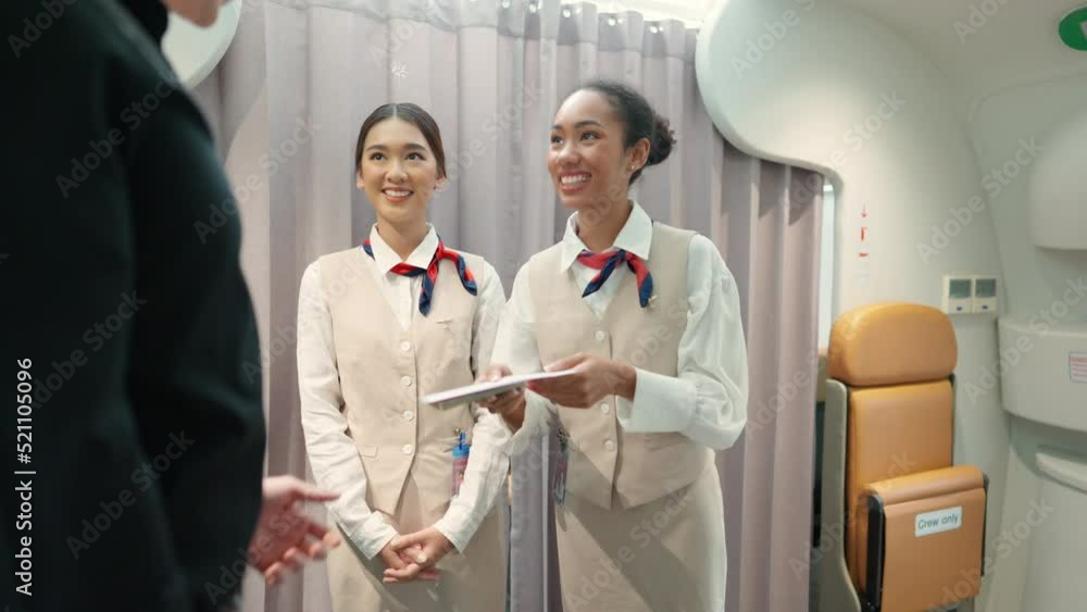 4K Woman flight attendant checking boarding pass and provide service to passenger in airplane. Passenger keep baggage in luggage compartment over the seat. Airline business and travel vacation concept 4K Woman flight attendant checking boarding pass and provide service to passenger in airplane. Passenger keep baggage in luggage compartment over the seat. Airline business and travel vacation concept