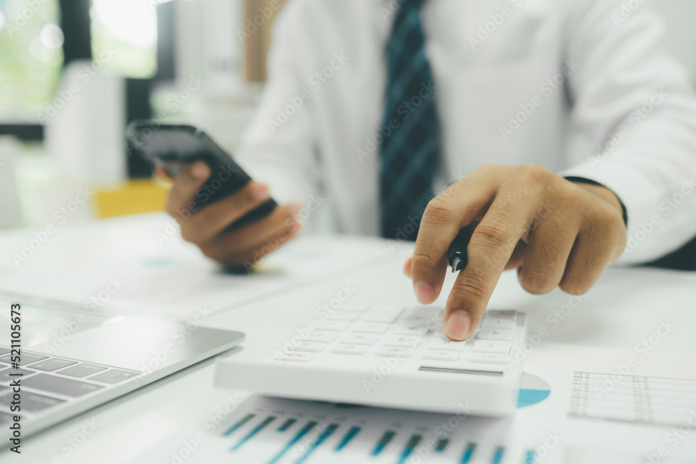 Young Asian startup businessman using smartphone to analyze online marketing information. Young Asian startup businessman using smartphone to analyze online marketing information.