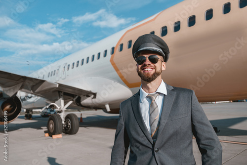 Cheerful aircraft pilot standing outdoors at airport