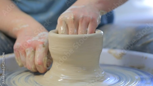 Potter at work making a clay bowl on a pottery wheel