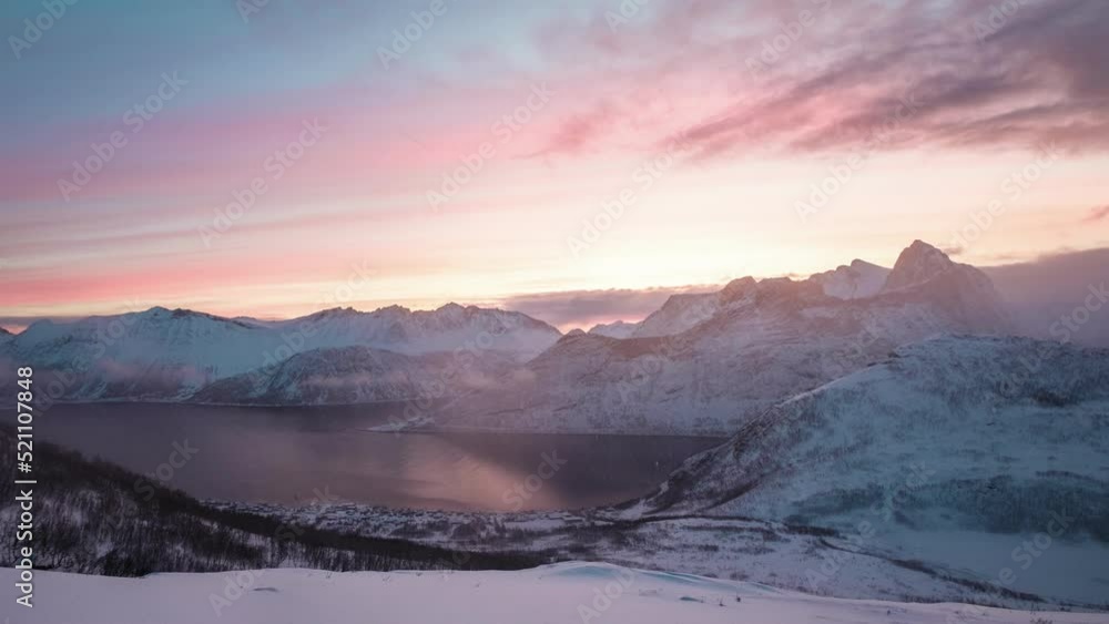 Sunrise over snowy mountain peak in blizzard on Segla mount in the morning at Senja island, Norway Sunrise over snowy mountain peak in blizzard on Segla mount in the morning at Senja island, Norway