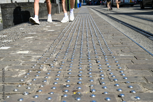 Tactile paving on sidewalk in the city. Tactile blister concrete blocks to assist pedestrians who are vision impaired. 