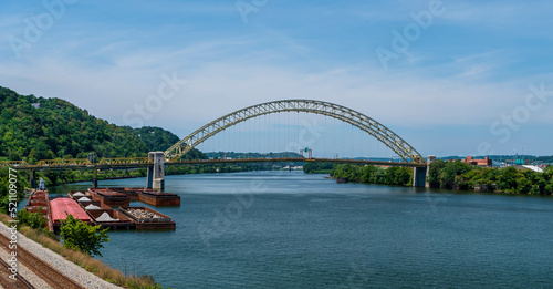 The West End Bridge that spans the Ohio River and connects the north side and the west end in Pittsburgh, Pennsylvania, USA. Several barges and a tugboat are moored to the west end shoreline © woodsnorth