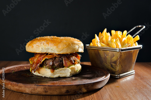 the photograph shows a delicious hamburger accompanied by french fries