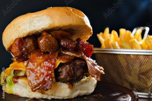 the photograph shows a delicious hamburger accompanied by french fries
