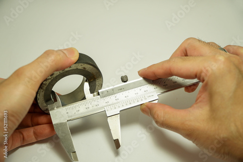 Papier peint engineer's hand uses a vernier caliper that is checked with a ring gauge,calibra
