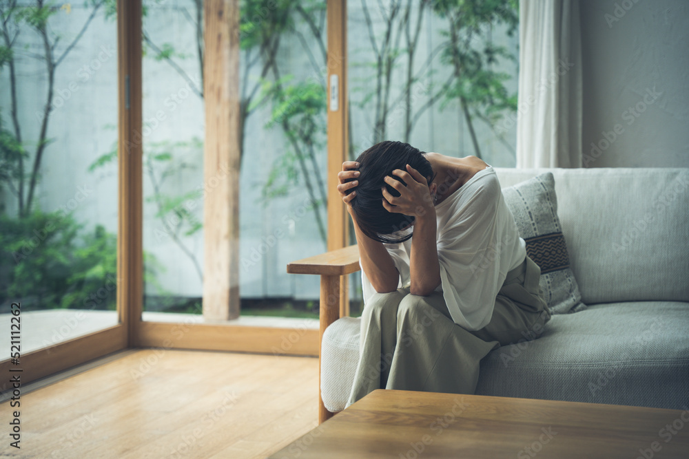 リビングで落ち込むミドル女性