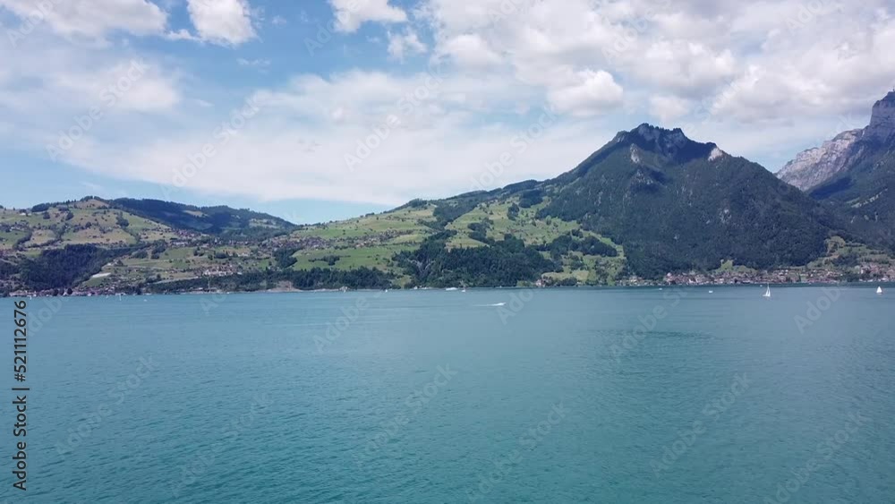 Arial shot Pan up of boat, lake and swiss mountains Arial shot Pan up of boat, lake and swiss mountains