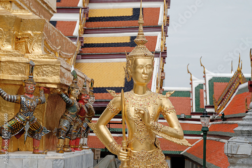 Kinnaree statue holding a sword look gracefully in wat phra keaw. photo