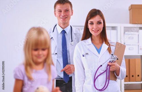 Female doctor examining child with stethoscope at surgery