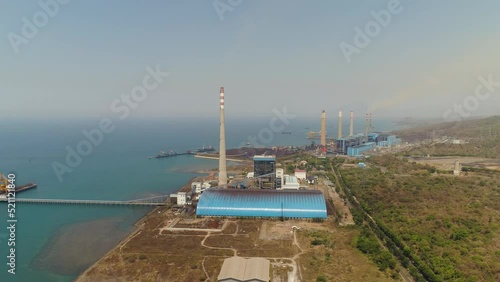 power station by sea with smoking pipes, paiton java, indonesia. aerial view power plant in asia. photo