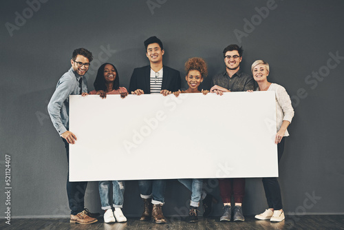 Fotografi A group of professionals holding a blank board or sign with copy space on a grey background