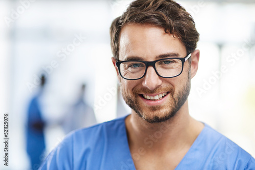 Portrait of a happy professional young doctor working as a surgeon in a hospital. Confident man in the medical healthcare workspace. Expert man in health smiling and ready to help or aid patients.
