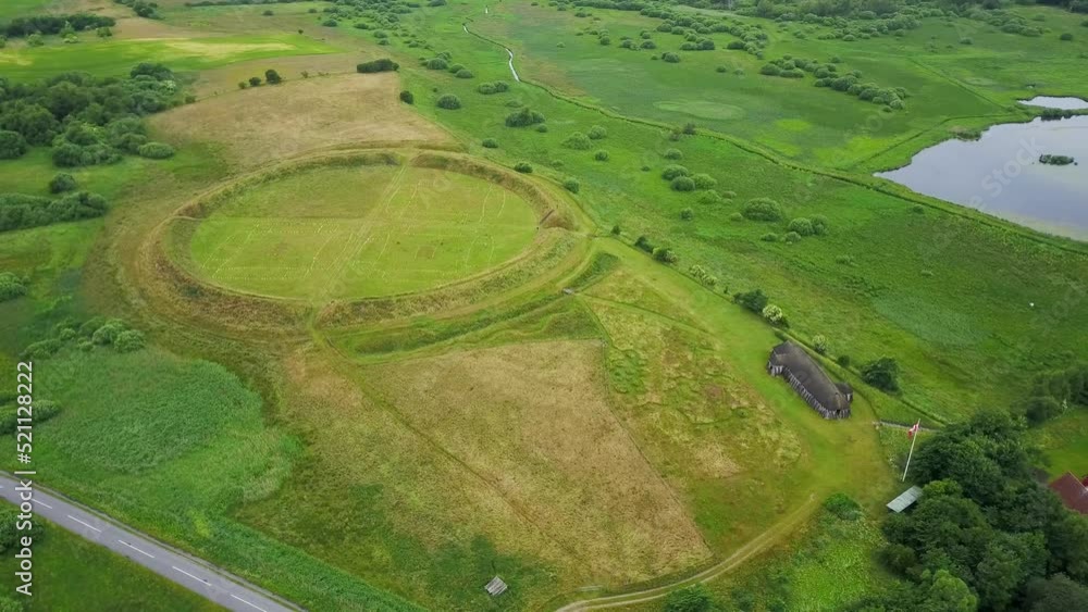Aerial view around the Fyrkat Viking ring castle ruins, cloudy, summer day in Hobro, Danmark - circling, drone shot Aerial view around the Fyrkat Viking ring castle ruins, cloudy, summer day in Hobro, Danmark - circling, drone shot