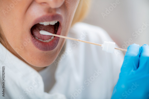 Fototapeta Naklejka Na Ścianę i Meble -  Inserting a swab into the mouth, collecting a saliva sample for DNA analysis